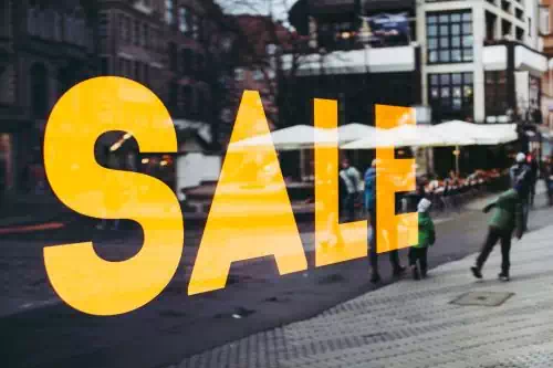 An image of a shop with the sale sign on its glass wall